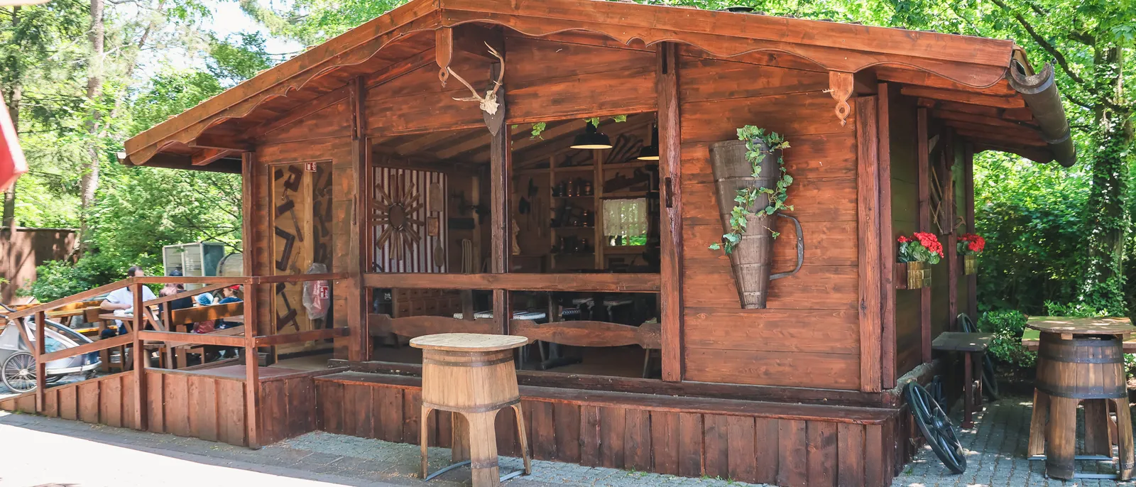 Chalet en bois avec terrasse et bois de cerf en décor, entouré d’arbres, à Europa-Park