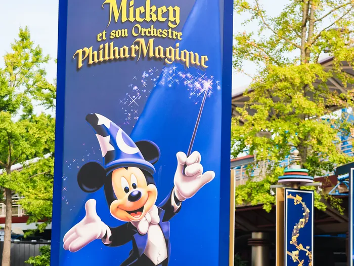 Panneau bleu de Mickey et son Orchestre PhilharMagique montrant Mickey apprenti sorcier, baguette levée, à Discoveryland.