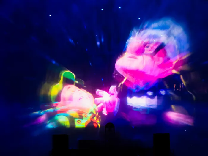 Buzz l'Éclair et un personnage de Toy Story projetés en couleurs sur les jets d'eau du spectacle nocturne