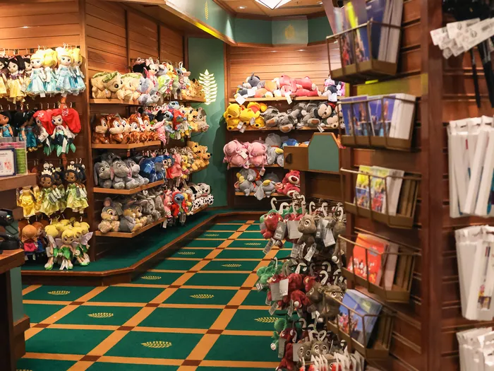 Aisle in the shop lined with soft toy shelves and displays, with a green chequered floor