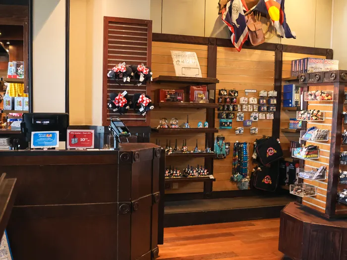 Wooden till counter and wall displays of Disney souvenirs in the General Store shop.