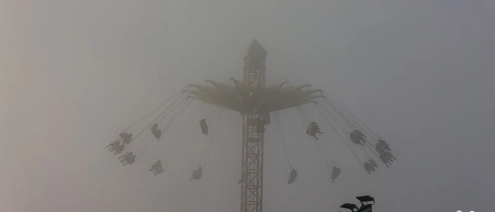 La Tour de Numérobis noyée dans un brouillard épais, nacelles à peine visibles au bout de leurs chaînes