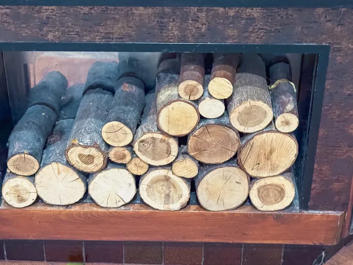 Rondins de bois coupés et empilés dans l’âtre de la cheminée du restaurant Hunter’s Grill