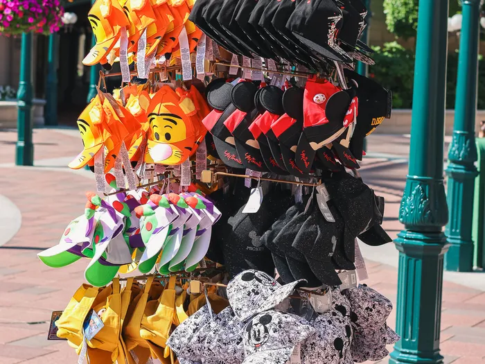 Outdoor display of Disney caps (Tigger, Mickey, Buzz Lightyear) at the Plaza East Boutique