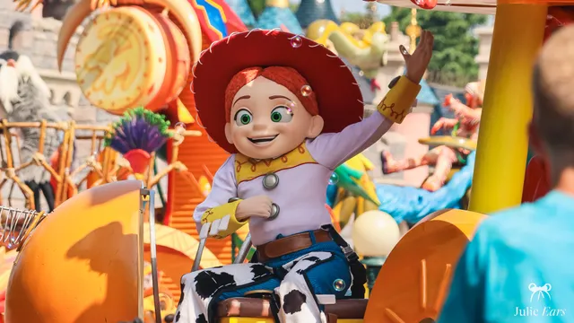 Jessie from Toy Story, with her hat and red hair, sits on her Disney Stars on Parade float and waves to visitors at Disneyland Paris