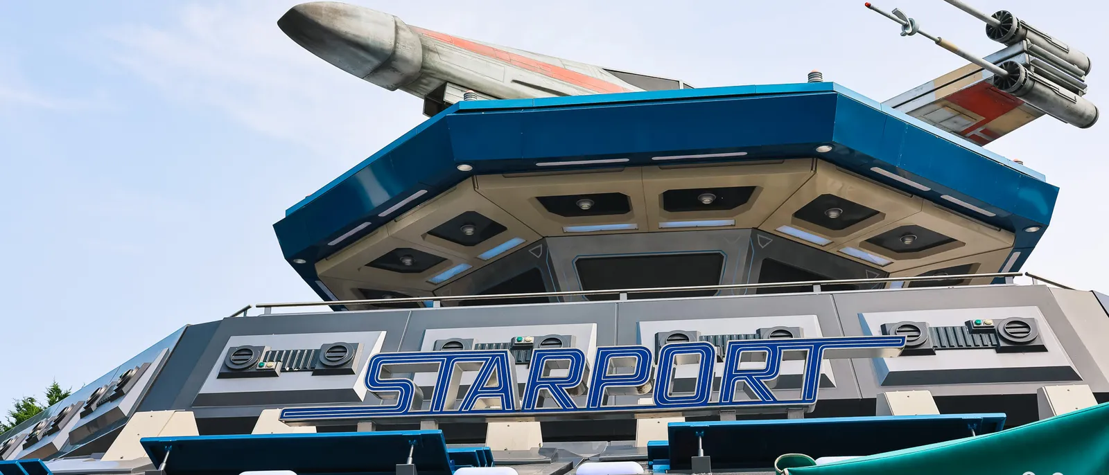 Enseigne bleue Star Port surmontée d’un X-wing sous un ciel dégagé, à Discoveryland, Disneyland Paris
