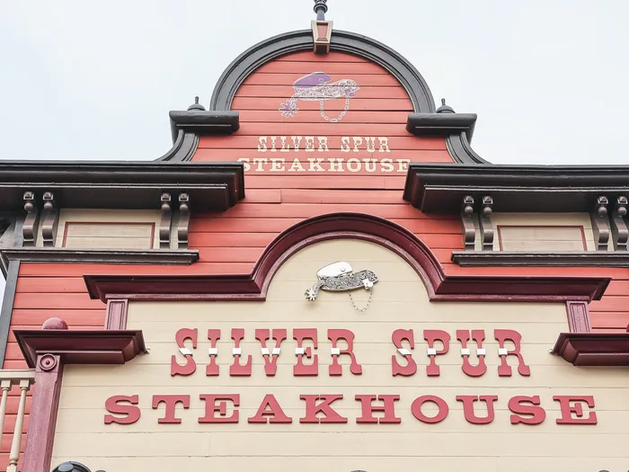 La façade en bois rouge et beige du Silver Spur Steakhouse, avec son enseigne western, à Frontierland.