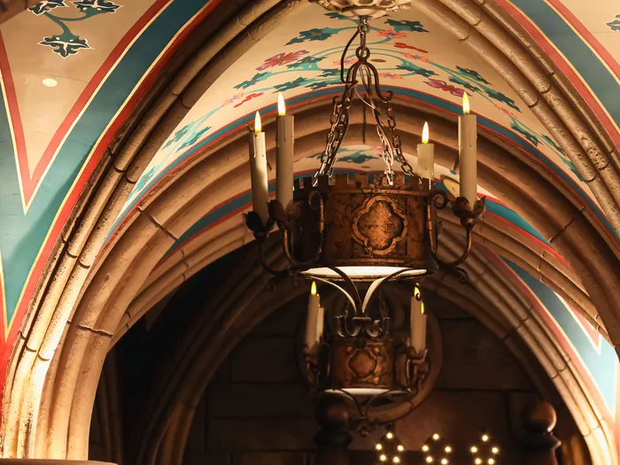 Plafond voûté peint et lustre en fer forgé de La Boutique du Château à Disneyland Paris.