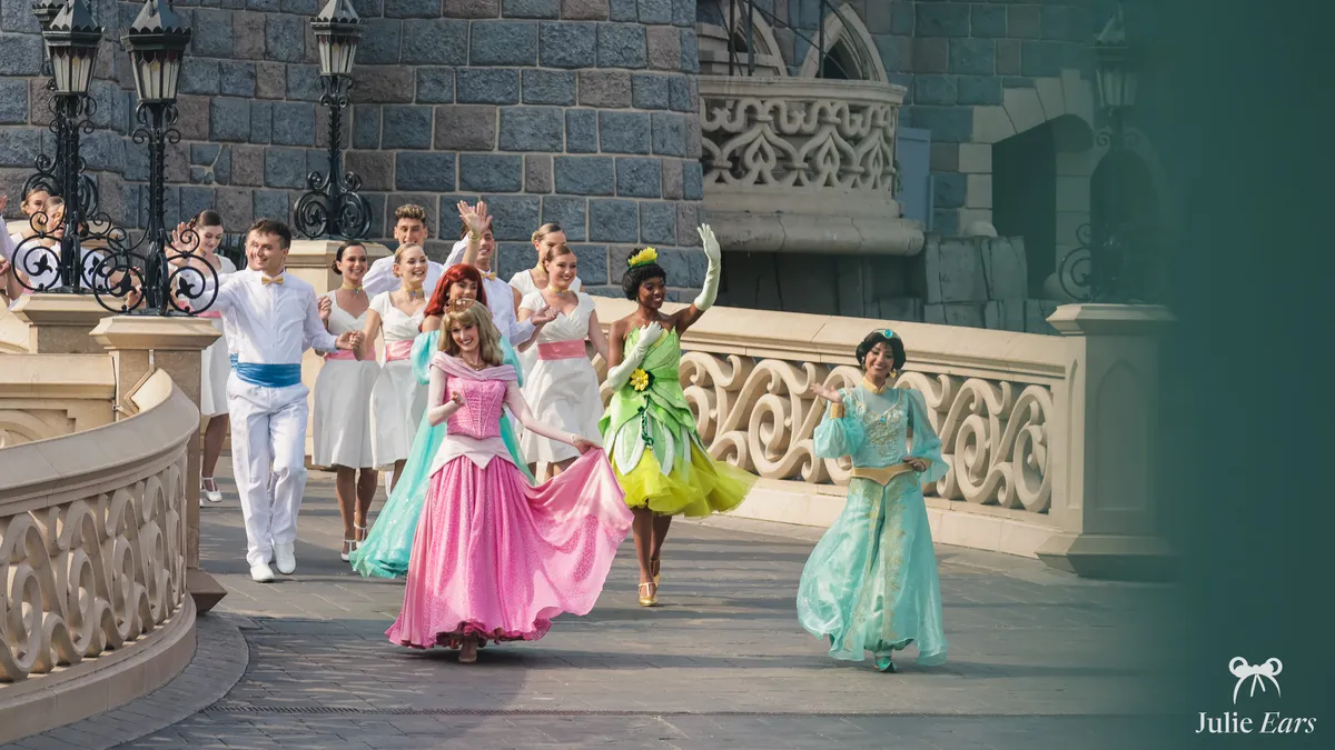 Les princesses Aurore, Tiana et Jasmine défilent avec des danseurs sur le pont du château, Disneyland Paris.