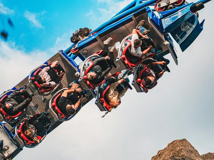 Train de Blue Fire plein de passagers plongeant sur sa voie bleue, vu d’en bas, à Europa-Park.