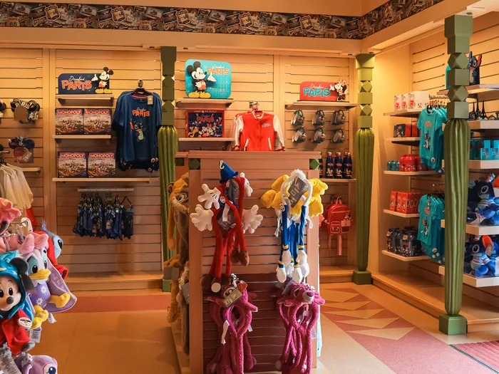 Inside the Trading Post at Disneyland Paris, clothing and soft toy displays under Mickey signs