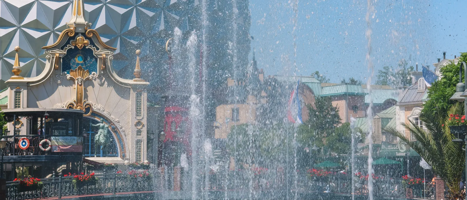 Grands jets d’eau rafraîchissants devant une sphère argentée et une façade dorée à Europa-Park
