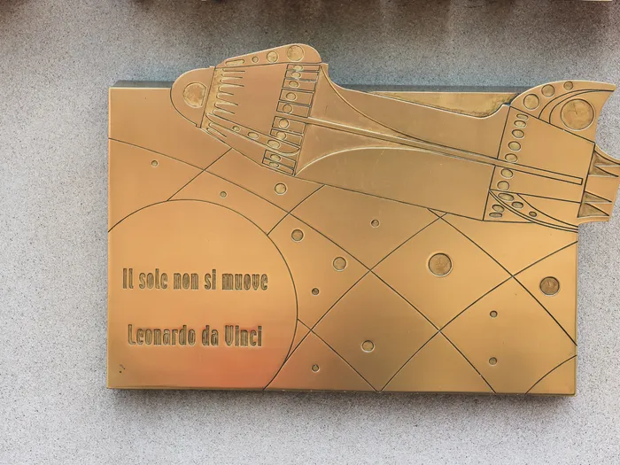 Plaque en bronze gravée d’une machine volante et de la devise « Il sole non si muove » de Leonardo da Vinci, à Orbitron.