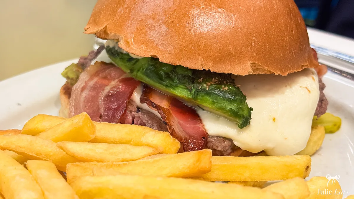 Burger with bacon, melted cheese and grilled broccoli, served with chips at Annette’s Diner, Disney Village.