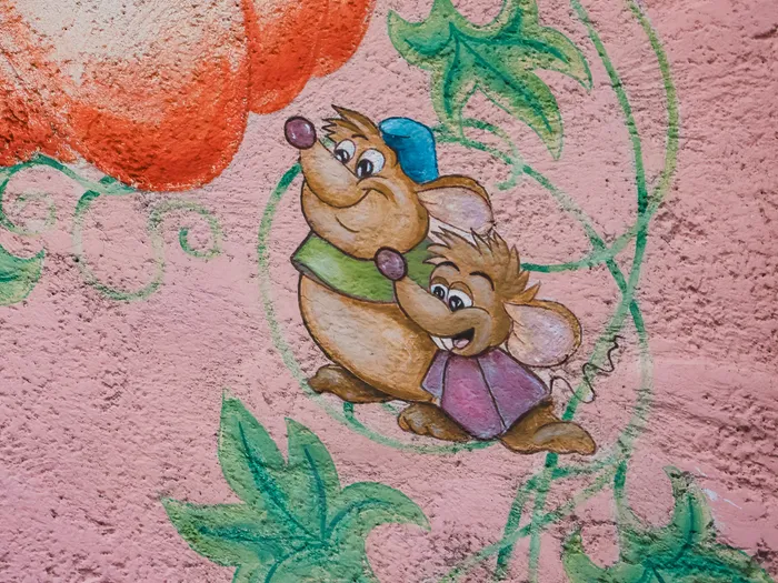 Fresque murale de Jaq et Gus, les souris de Cendrillon, sur un mur rose de l’Auberge de Cendrillon.