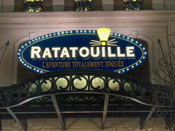 Enseigne ovale bleue de l’attraction Ratatouille éclairée d’ampoules la nuit