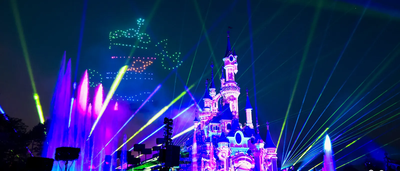 Château de la Belle au Bois Dormant illuminé de lasers, jets d’eau et drones pendant Disney Tales of Magic