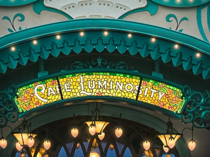 Enseigne en vitrail Art nouveau du Café Luminosity, façade verte ornée, à Disney Adventure World