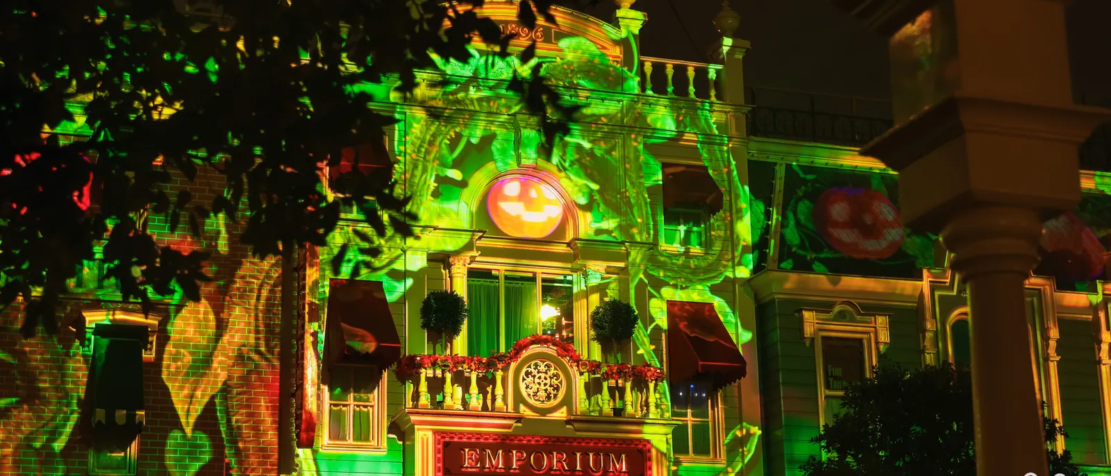 Façade de l’Emporium, sur Main Street, illuminée de vert avec des citrouilles projetées la nuit d’Halloween.