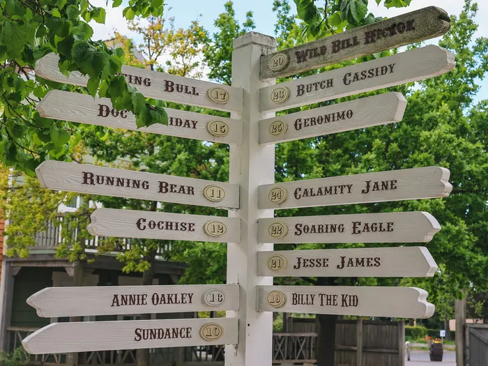 Poteau indicateur de l’Hotel Cheyenne avec les noms des rues du Far West, Calamity Jane et Billy the Kid.