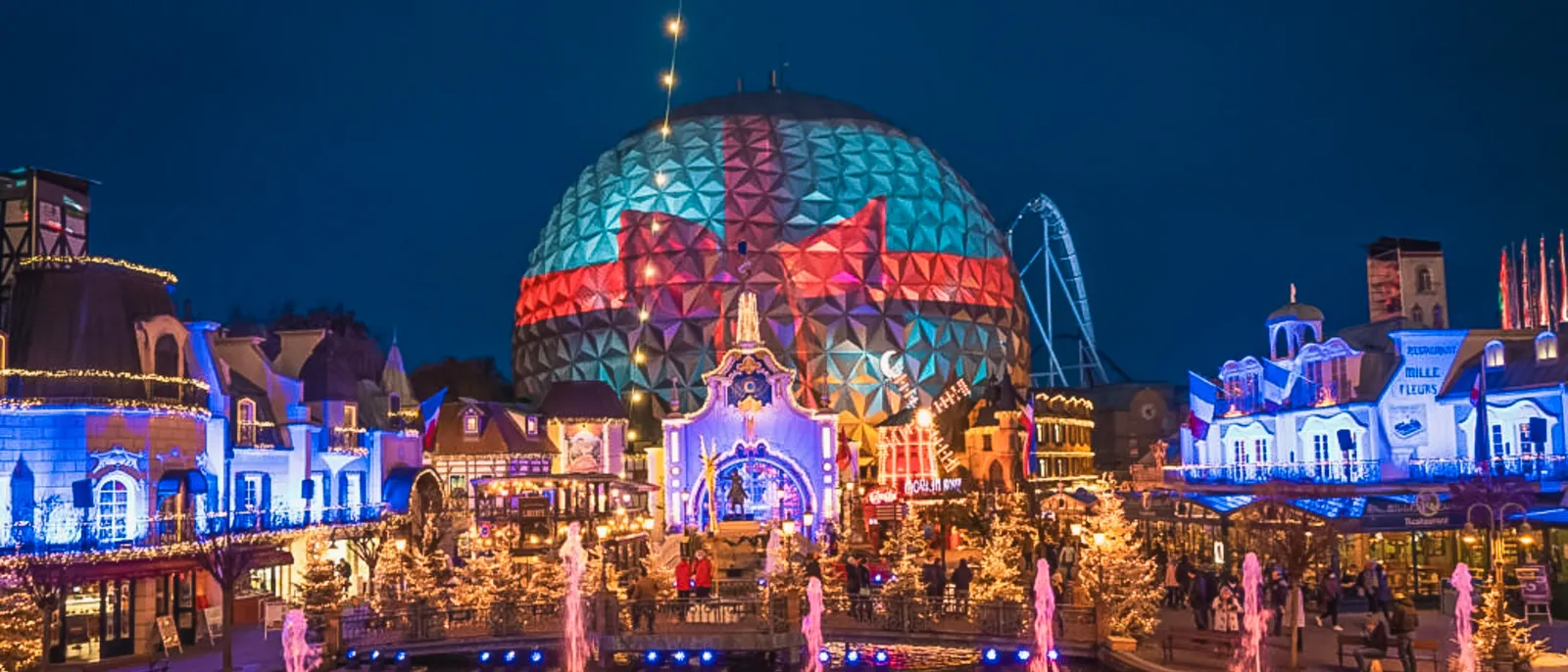 Grand dôme mosaïque illuminé et jets d’eau au crépuscule pendant les fêtes de Noël à Europa-Park