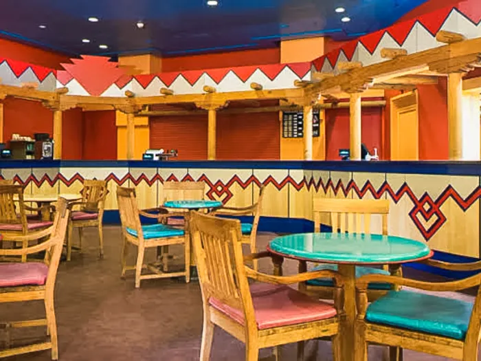 Tables turquoise et chaises en bois du Rio Grande Bar, décor coloré du Sud-Ouest au Disney Hotel Santa Fe.