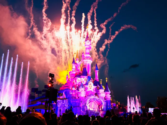 Feu d’artifice et jets d’eau colorés illuminent le château pendant le spectacle Disney Tales of Magic au Parc Disneyland.