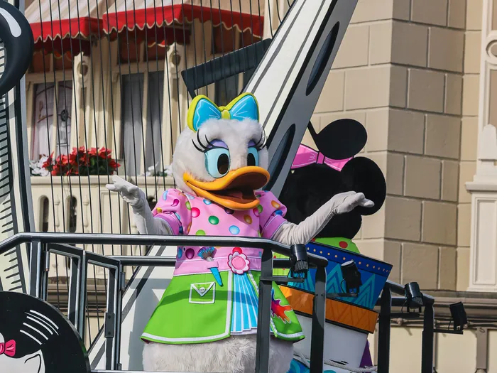 Daisy et Minnie sur un char décoré d'une harpe géante pendant la parade A Million Splashes of Colour, bulles de savon