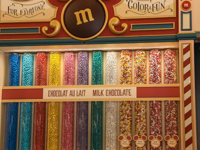 Mur de tubes de M&M’s au chocolat au lait multicolores au Boardwalk Candy Palace, Main Street U.S.A., Disneyland Paris