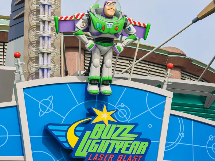 Figure de Buzz l’Éclair dressée au-dessus de l’enseigne bleue de Buzz Lightyear Laser Blast, Discoveryland.