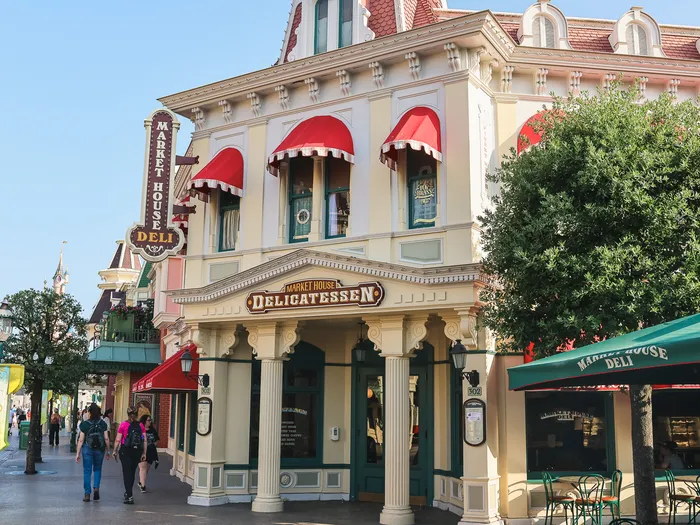 Le bâtiment d'angle du Market House Deli, avec ses stores rouges et son enseigne « Delicatessen », Main Street USA.