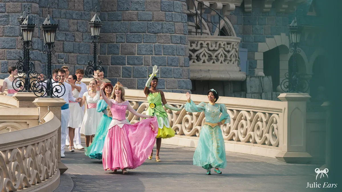 Several Disney princesses (Aurora, Jasmine, Tiana…) parade on the castle bridge during World Princess Week at Disneyland Paris.