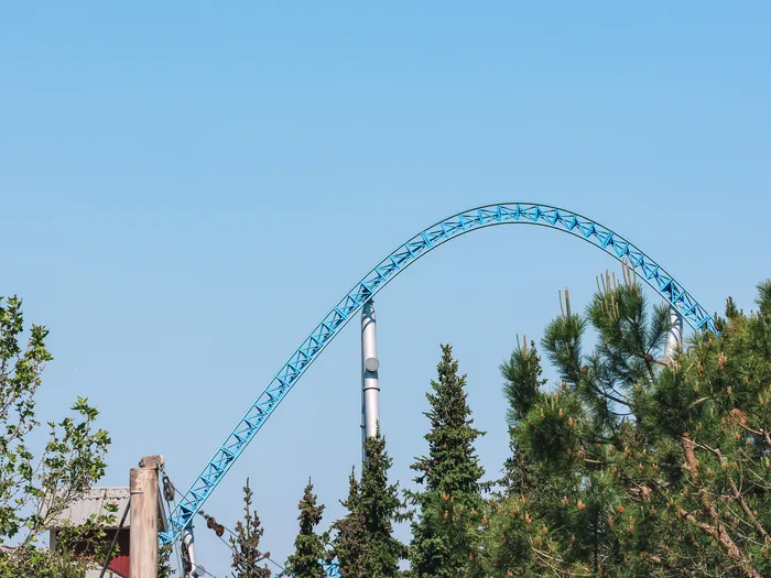 Haute courbe bleue du coaster Blue Fire s’élançant au-dessus des cimes des arbres à Europa-Park.