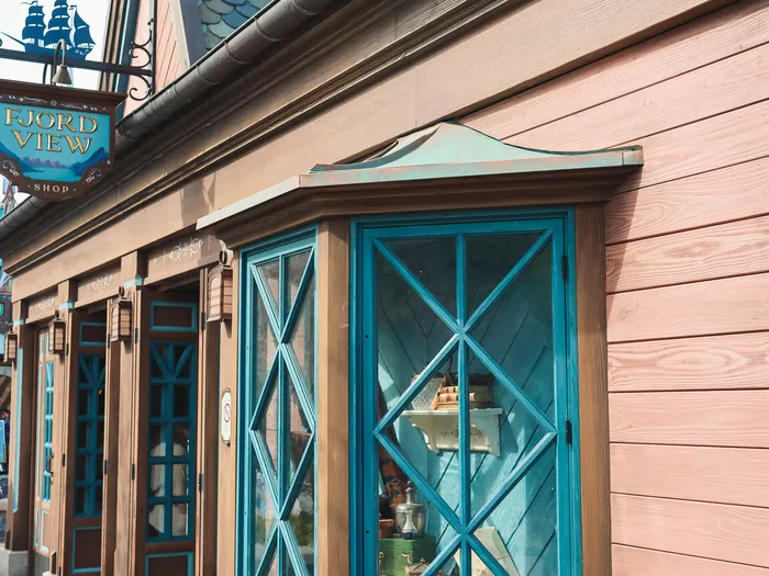 Salmon-pink wooden frontage of the Fjord View Shop, with turquoise lattice windows