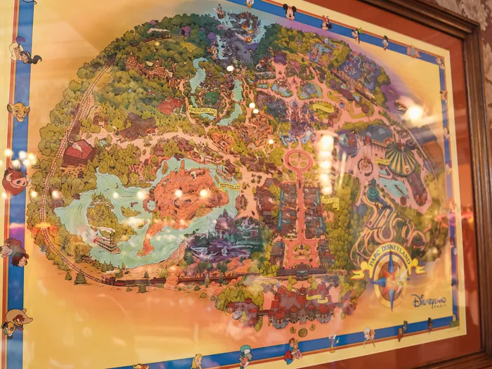 Framed illustrated map of Disneyland Park, hanging in the Plaza East Boutique