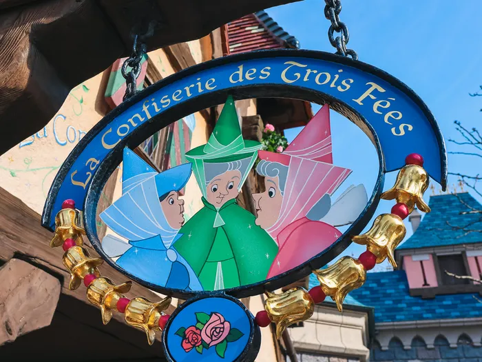 Hanging sign of La Confiserie des Trois Fées at Disneyland Paris.