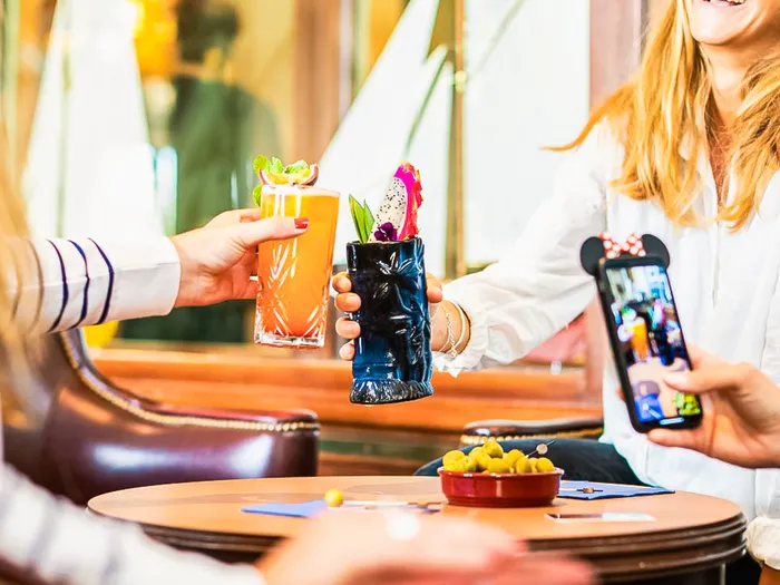 Clients trinquant avec des cocktails colorés au bar Captain’s Quarters