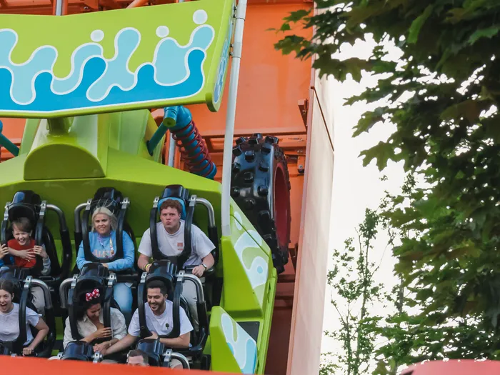 Passagers assis dans le wagon vert de l’attraction RC Racer à Toy Story Playland