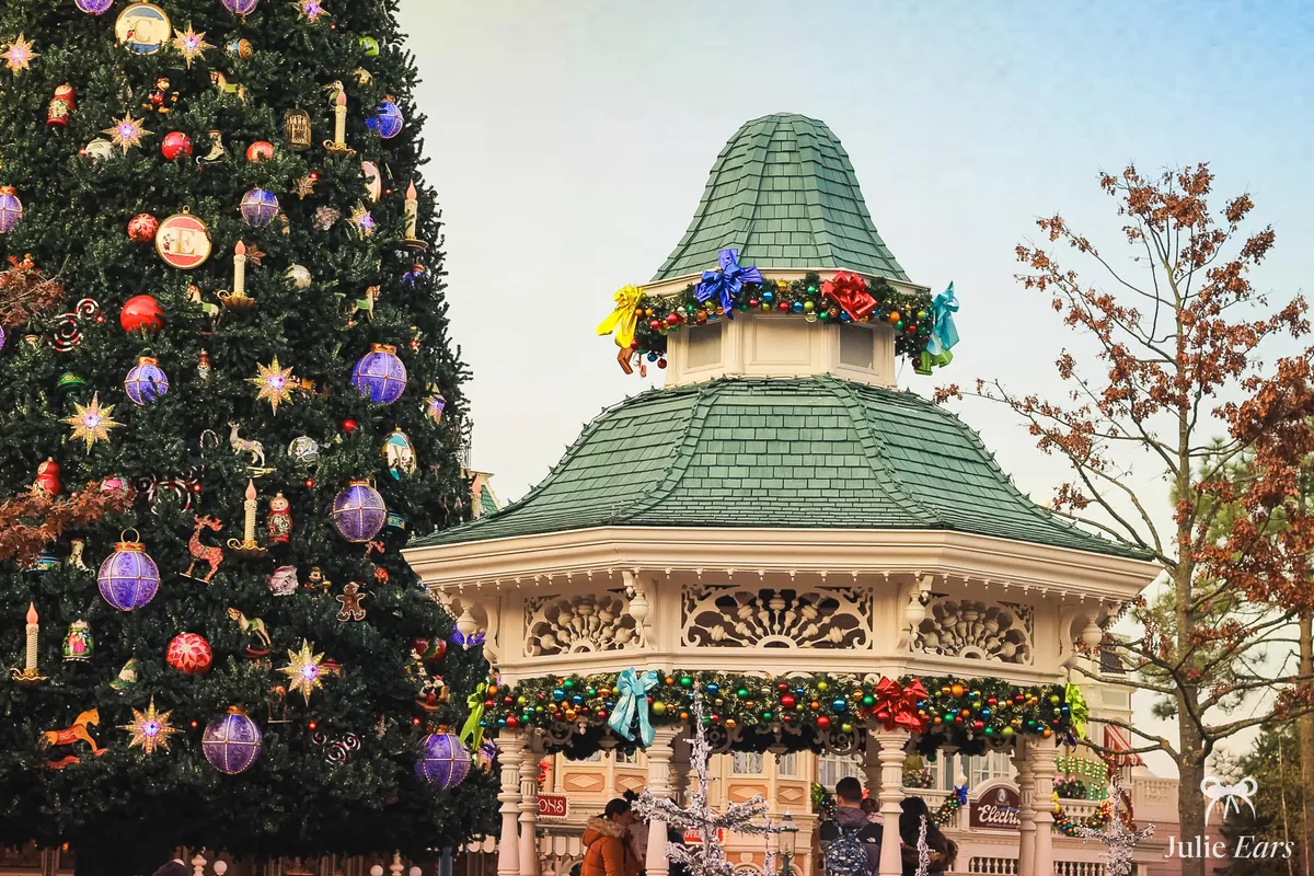 Grand sapin de Noël illuminé et kiosque de Town Square décoré à Disneyland Paris