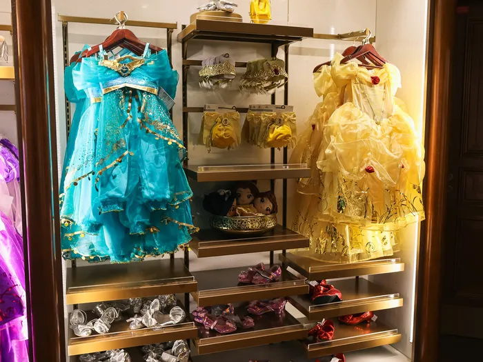 Robes de princesses sur cintres, dont une robe turquoise de Jasmine et une jaune de Belle
