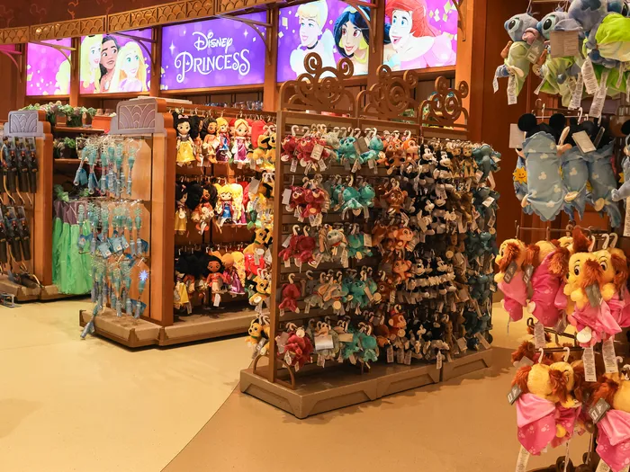 Disney Princess area with soft toys and princess dresses hanging on wooden displays.