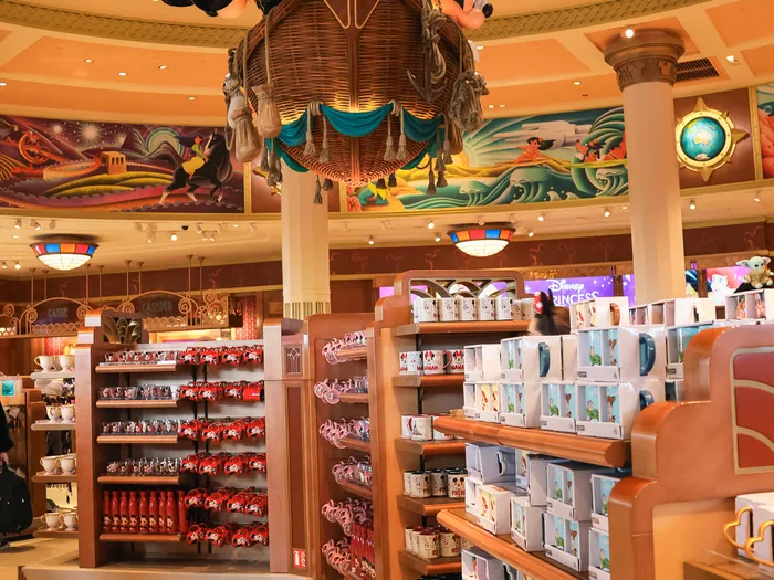 Shelves of mugs and cups under the hot air balloon basket inside the store.