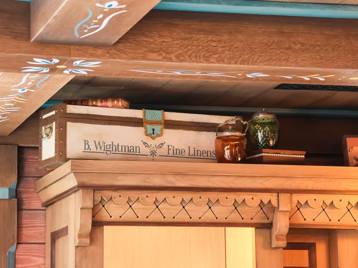 Painted beams and a "B. Wightman Fine Linens" sign inside the shop