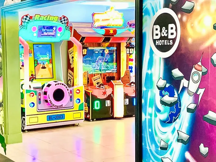 Bornes d'arcade colorées dans la salle de jeux du B&B Hotel Disney