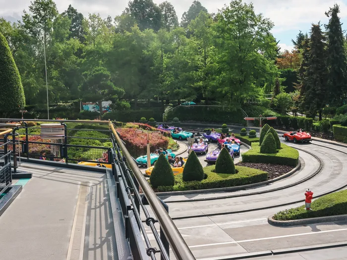 Vue en hauteur du circuit d’Autopia avec ses voitures colorées, ses haies taillées et sa verdure, à Discoveryland.