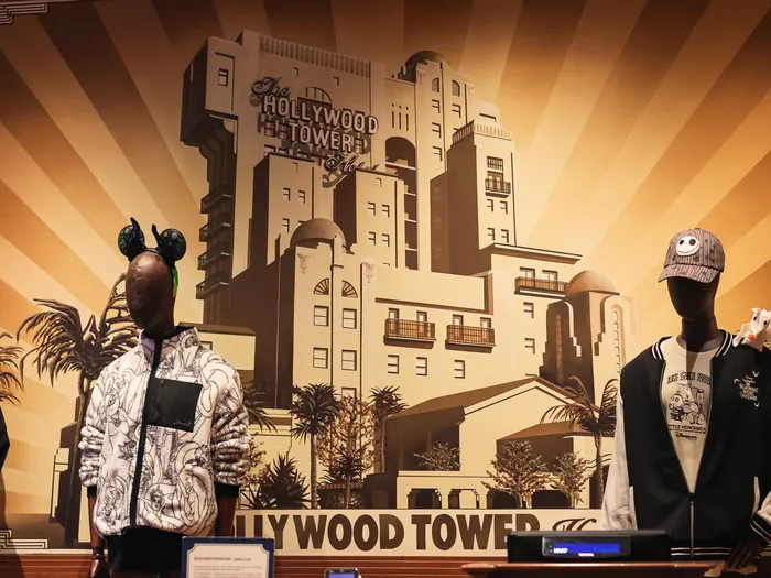 Art Deco Hollywood Tower Hotel mural behind three mannequins, including a Jack Skellington cap and jacket, at Disneyland Paris