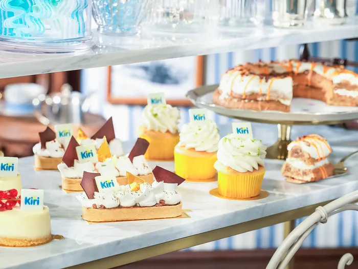 Présentoir de pâtisseries de la marque Kiri (cheesecakes, éclairs, cupcakes) sur un chariot en marbre, au Cable Car Bake Shop