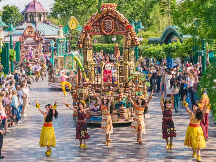 Danseuses en jupes de paille défilant devant un char de la cavalcade 626 Celebration