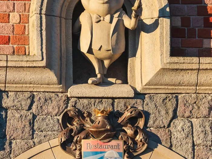 Statue en pierre du crapaud en habit et blason au-dessus de l’entrée de Toad Hall Restaurant