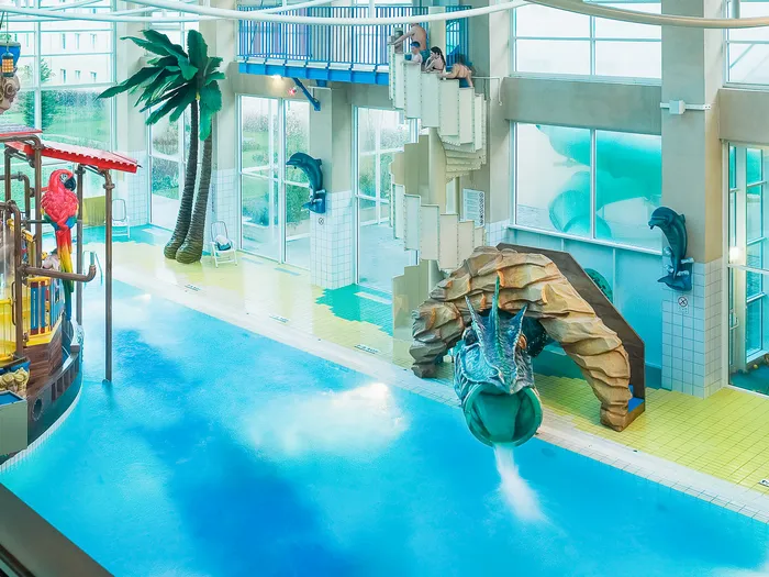 Aire de jeux aquatique de l’Explorers Hotel avec bateau pirate, toboggan crocodile et palmier